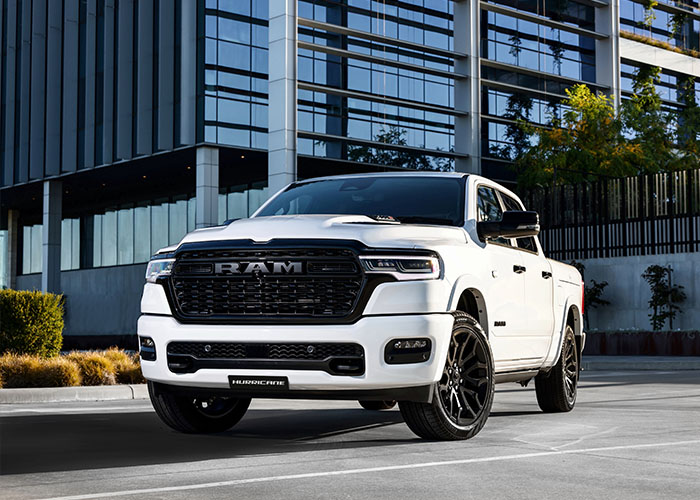 White RAM truck parked on conrete infront of a building